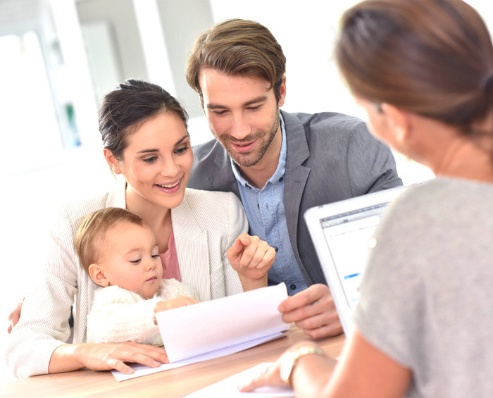 a couple with a baby looking at paperwork