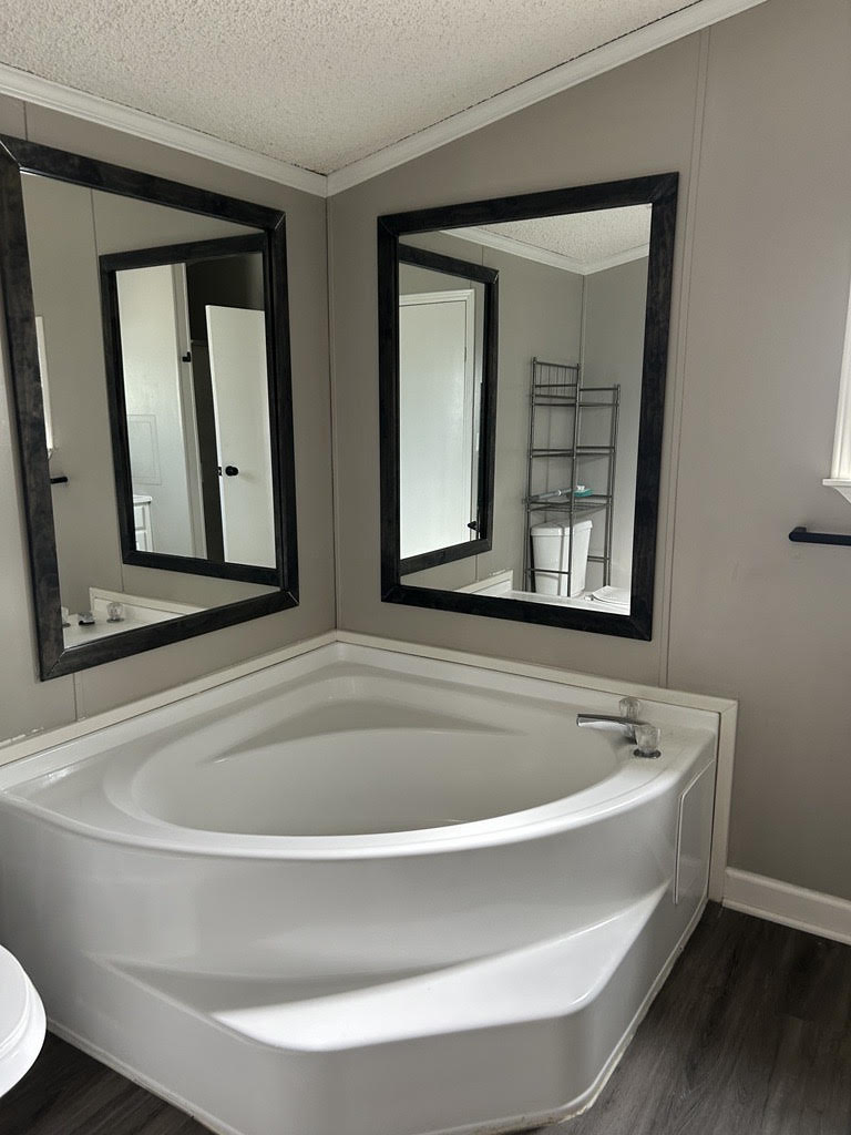 master bathroom with a large bathtub and mirror
